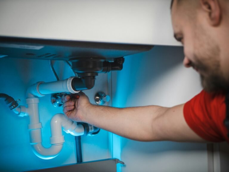 Licensed plumber repairing water pipes inside a wall in a Peoria Heights, IL home